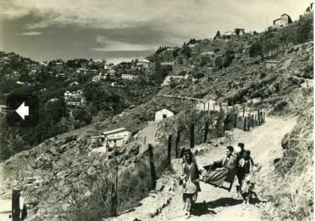 Lowell Thomas being carried along a road in a dandy chair.PNG